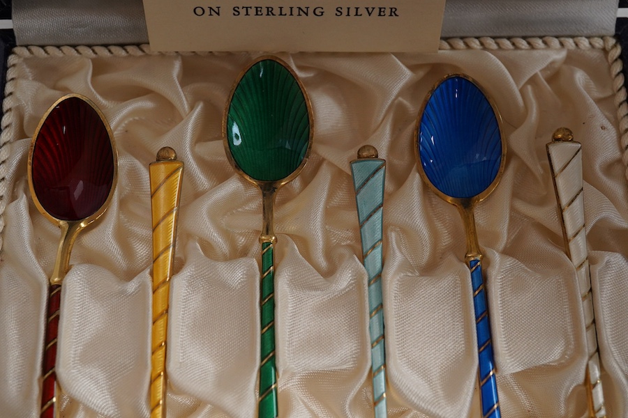 A mid 20th century cased set of six Danish gilt sterling and polychrome enamel coffee spoons, by Egon Lauridson, 94mm, together with one other set of six white metal and enamelled teaspoons, stamped 'silver'. Condition -